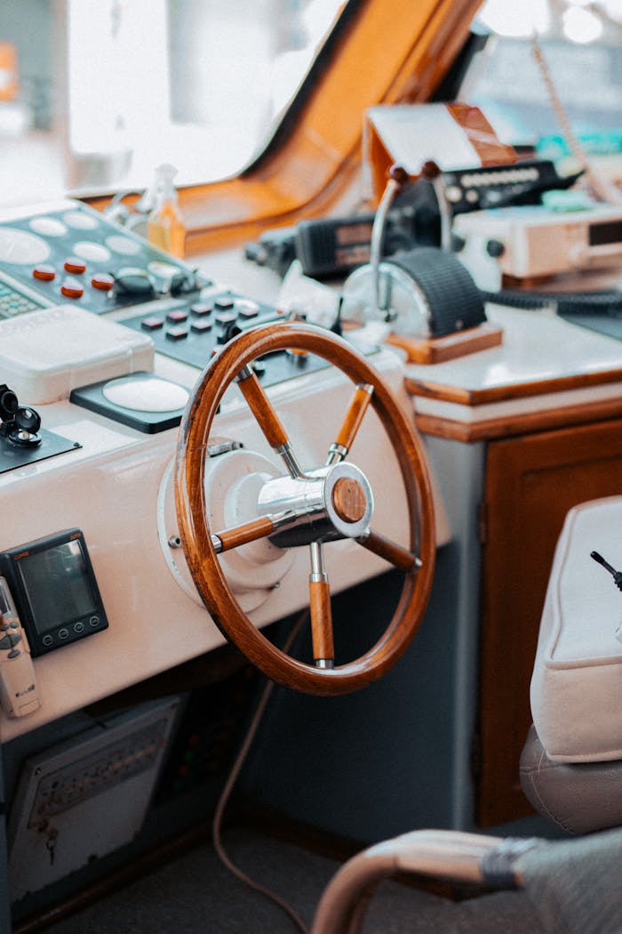 Interior view of a boat cockpit featuring a wooden steering wheel and control panel.