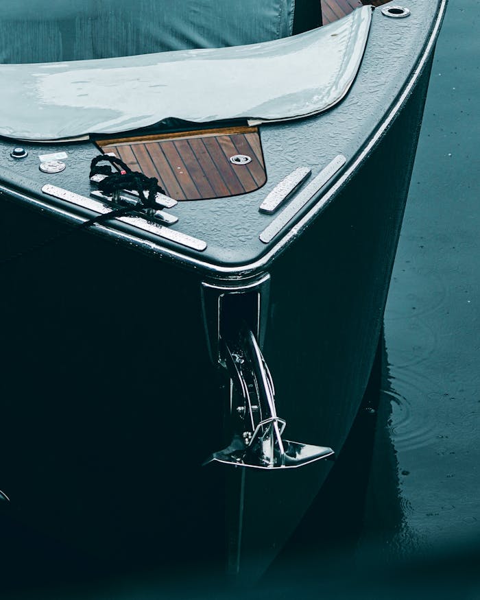 Close-up view of a sleek boat's bow anchored on calm water, capturing elegance and travel essence.