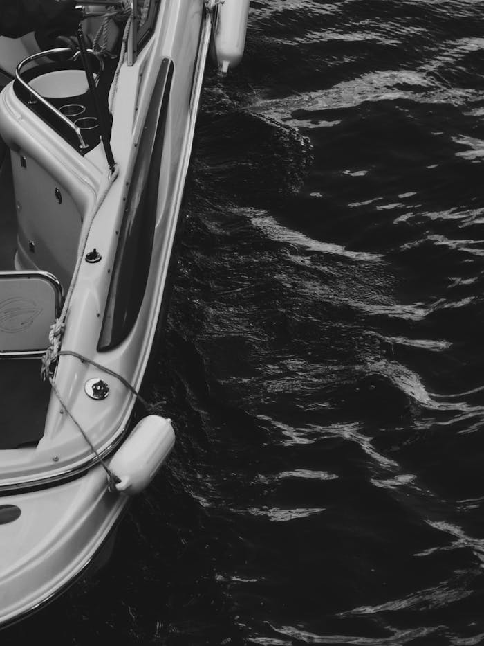 Artistic black and white photo of boat on water showcasing marine travel.