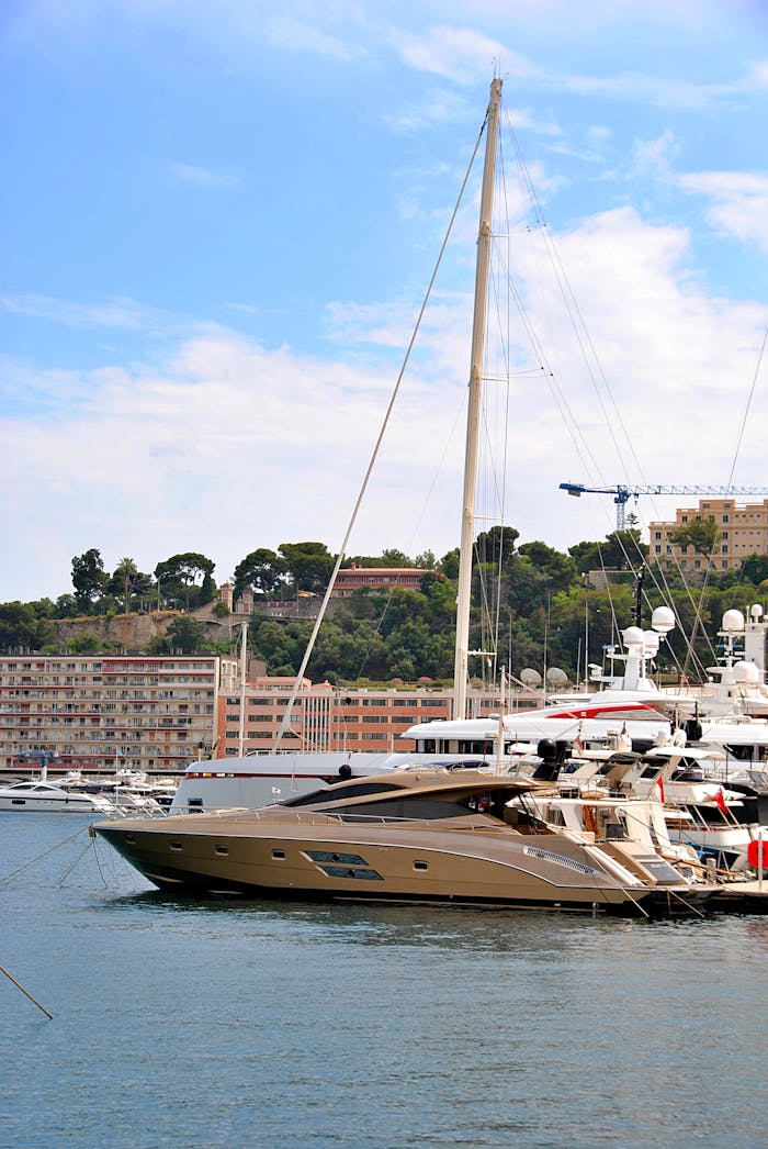 Elegant yachts docked at a marina in Monaco under clear blue skies. Perfect summer getaway.