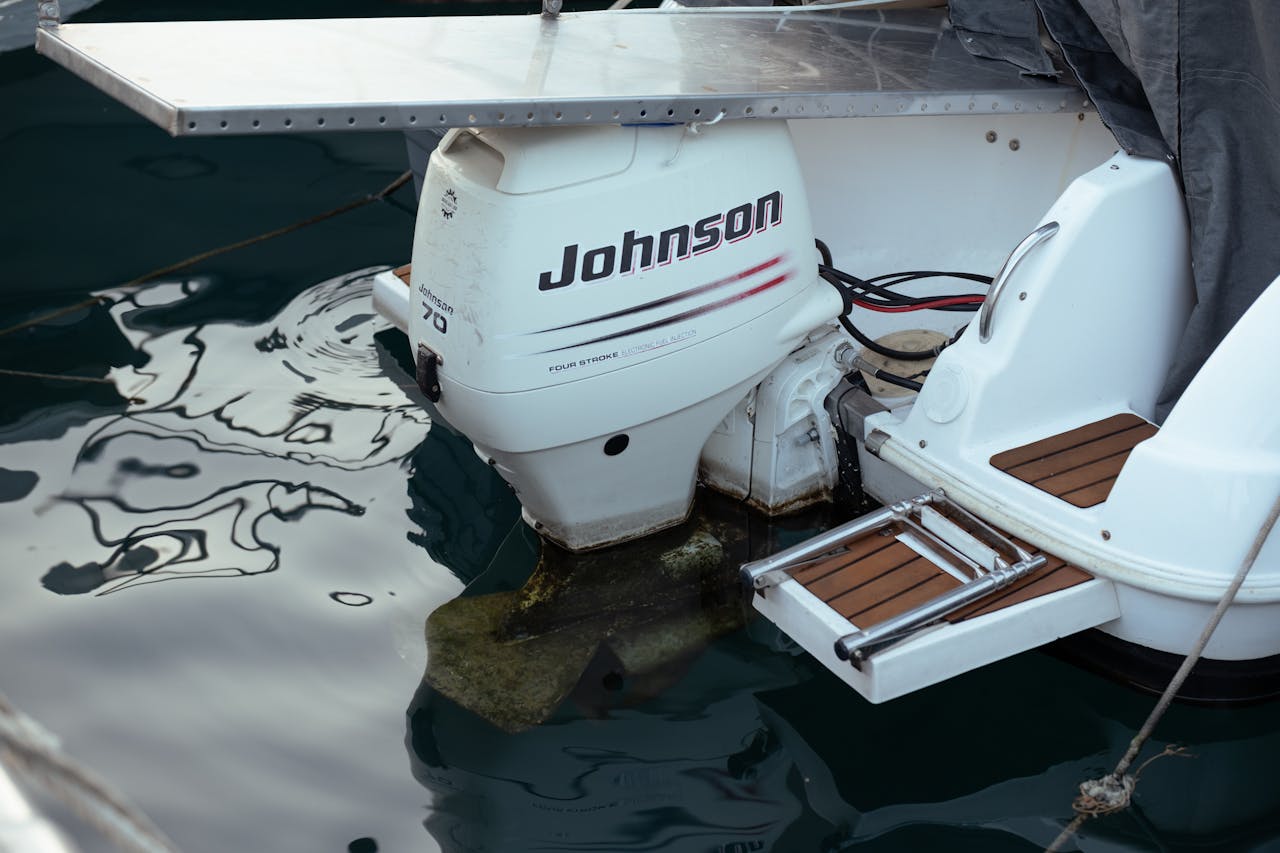Close-up detail of a boat's Johnson outboard motor in calm waters. Perfect for marine and nautical themes.