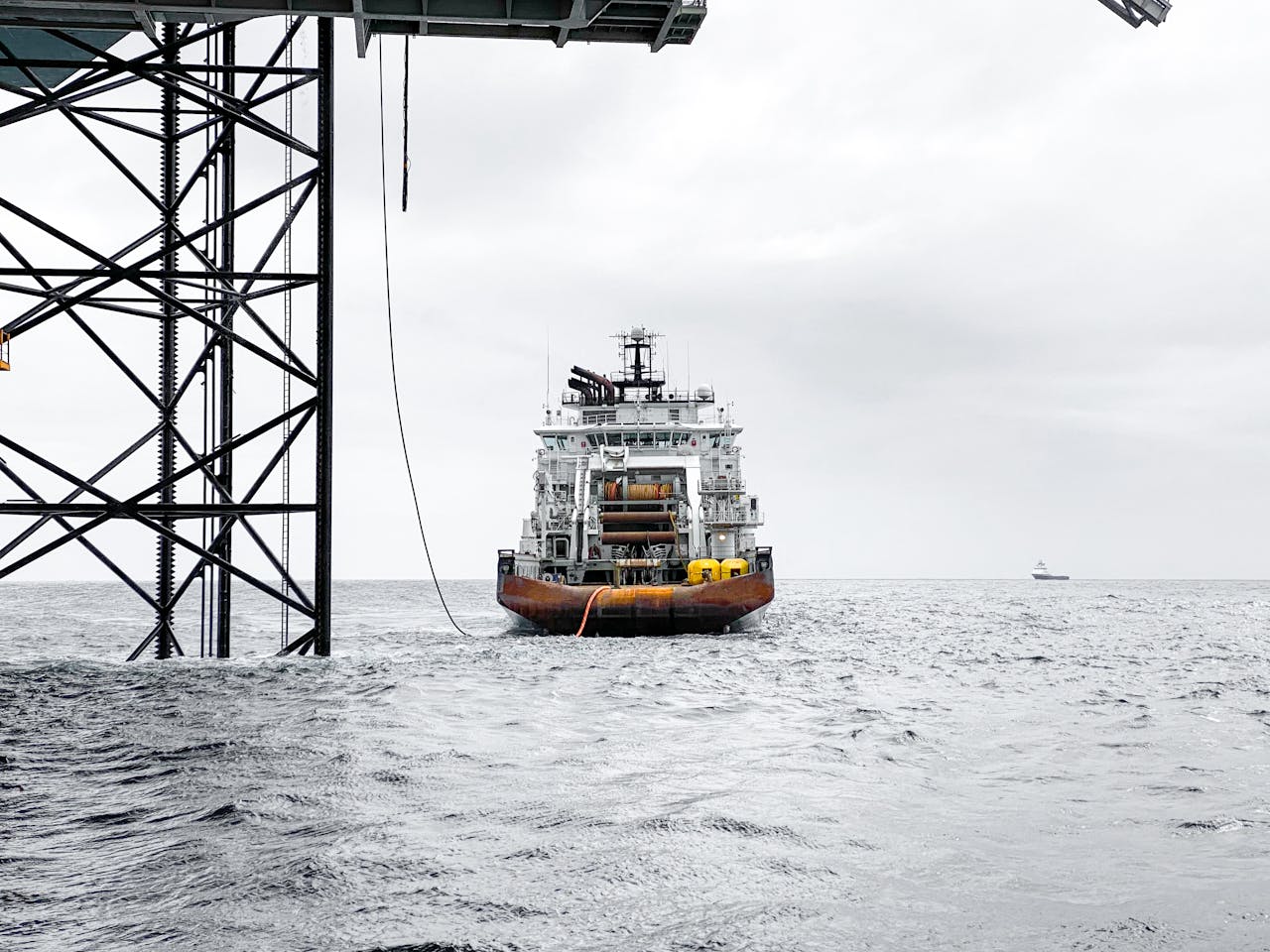 A large vessel near an offshore oil platform in the Norwegian Sea, overcast weather.